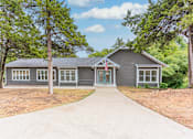 Thumbnail 11 of 19 - the front of a house with a driveway and trees