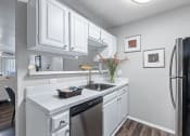 Thumbnail 14 of 17 - a kitchen with white cabinets and a stainless steel refrigerator