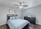 Thumbnail 15 of 17 - the master bedroom has a large bed and a ceiling fan