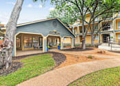 Thumbnail 22 of 28 - A tree is in front of a building with a sign that says "Leasing Office".