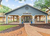 Thumbnail 23 of 28 - A leasing office building with a blue roof and a sign on the front.
