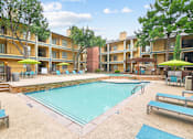 Thumbnail 20 of 28 - A swimming pool surrounded by apartment buildings and lounge chairs.