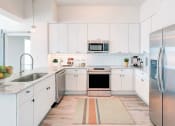 Thumbnail 1 of 14 - a kitchen with white cabinets and stainless steel appliances