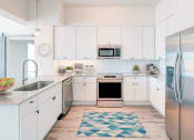 Thumbnail 2 of 23 - a kitchen with white cabinets and stainless steel appliances