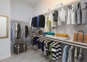 Thumbnail 7 of 23 - a rack of clothes and bags in a closet