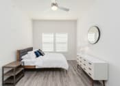 Thumbnail 15 of 23 - a bedroom with a bed and a dresser and a ceiling fan