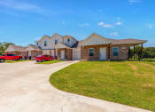 Thumbnail 17 of 21 - a house with two red cars parked in front of it