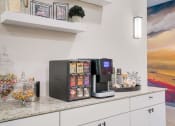 Thumbnail 20 of 23 - a kitchen with a coffee machine and a counter top with food on it