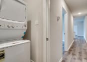 Thumbnail 12 of 20 - a laundry room with a washer and dryer and a hallway with a door