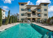 Thumbnail 1 of 14 - a large swimming pool in front of a building