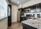 Thumbnail 2 of 14 - a kitchen with stainless steel appliances and granite counter tops