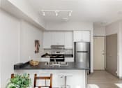 Thumbnail 4 of 15 - A modern kitchen with stainless steel appliances and a wooden countertop.