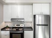 Thumbnail 12 of 15 - A modern kitchen with a stainless steel refrigerator, oven, and cabinets.