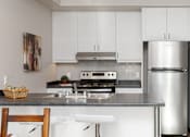 Thumbnail 10 of 15 - A kitchen with white cabinets and a stainless steel refrigerator.
