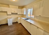 Thumbnail 5 of 14 - a kitchen with white cabinets and a sink and a window