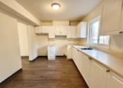 Thumbnail 4 of 14 - an empty kitchen with white cabinets and a window