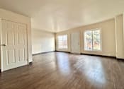 Thumbnail 11 of 14 - an empty living room with wood floors and a white door