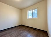 Thumbnail 7 of 14 - an empty room with a window and wooden floors