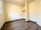Thumbnail 8 of 14 - a empty room with a wood floor and white walls