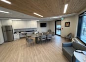 Thumbnail 15 of 15 - A modern kitchen with a dining table and chairs.