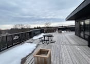 Thumbnail 14 of 15 - A deck with a table and chairs covered in snow.