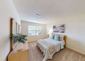 Thumbnail 7 of 11 - A bedroom with a bed, dresser, and mirror.