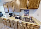 Thumbnail 4 of 15 - A kitchen with wooden cabinets and a sink.