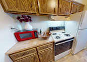 Thumbnail 3 of 15 - A kitchen with wooden cabinets and a red microwave.