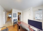 Thumbnail 8 of 21 - A room with a desk and a chair in it.