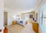 Thumbnail 13 of 21 - A bedroom with a bed, nightstand, and window.