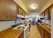 Thumbnail 6 of 21 - A kitchen with wooden cabinets and a white refrigerator.