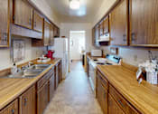 Thumbnail 3 of 21 - a galley style kitchen with a refrigerator and stove