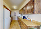 Thumbnail 6 of 17 - a kitchen with wooden cabinets and a refrigerator