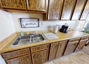 Thumbnail 9 of 17 - A kitchen with wooden cabinets and a sign that says "Good Gratitude".