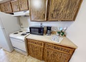 Thumbnail 10 of 17 - A kitchen with wooden cabinets and a white refrigerator.