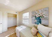 Thumbnail 16 of 17 - A bedroom with a bed, pillows, and a painting on the wall.