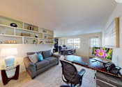 Thumbnail 13 of 19 - A well-lit room with a desk, chair, and a couch.