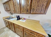 Thumbnail 9 of 19 - A kitchen with wooden cabinets and a wooden counter top.