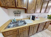 Thumbnail 10 of 19 - A kitchen with wooden cabinets and a double sink.