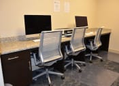 Thumbnail 23 of 24 - a large desk with four chairs and two computer monitors