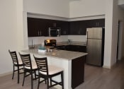 Thumbnail 13 of 24 - a kitchen with black cabinets and a granite counter top