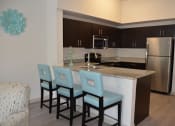 Thumbnail 11 of 24 - a kitchen with an island with four blue chairs in front of it