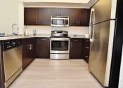 Thumbnail 12 of 24 - a kitchen with stainless steel appliances and wooden cabinets