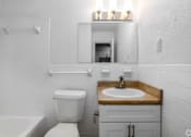 Thumbnail 5 of 22 - A white bathroom with a toilet, sink, and bathtub.
