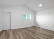 Thumbnail 3 of 22 - A room with a white door and a window with white frame.