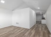 Thumbnail 1 of 22 - A room with wooden flooring and white walls.