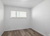 Thumbnail 20 of 22 - A room with a window and wooden flooring.