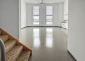 Thumbnail 11 of 22 - A white room with a staircase leading to the second floor.