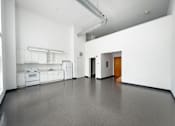 Thumbnail 14 of 22 - A spacious kitchen with white cabinets and appliances.
