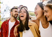 Thumbnail 5 of 22 - Three people are laughing together outdoors.